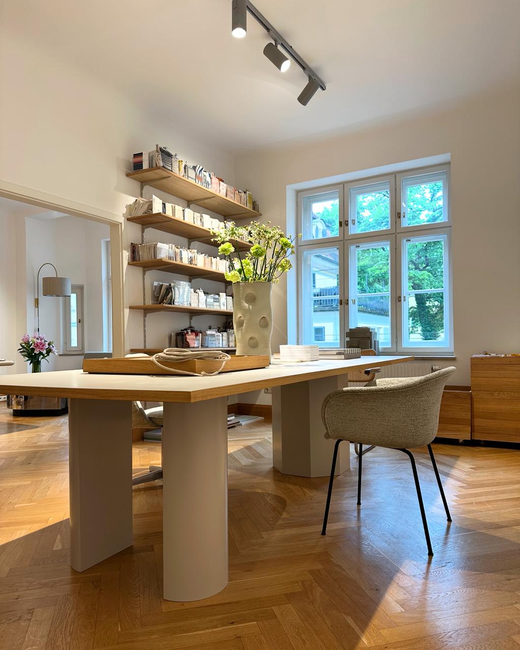 The Yasemin Loher Interiors studio with a large worktable and bookcase